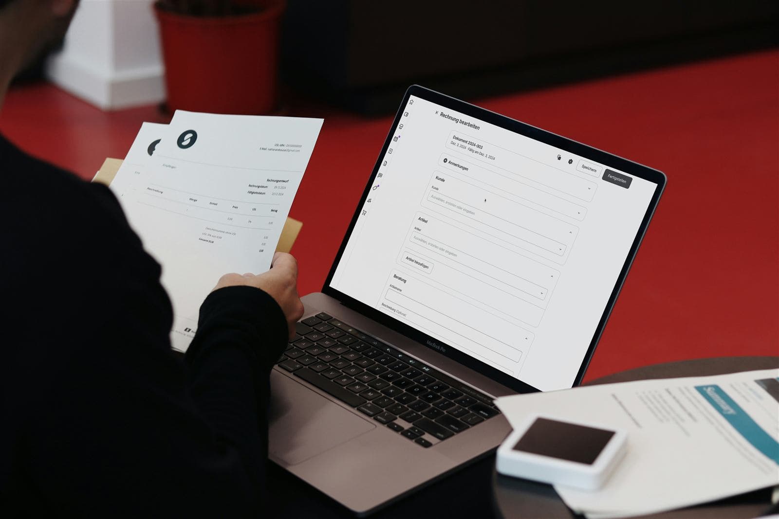 Fatture e documenti fiscali su una scrivania accanto a un laptop